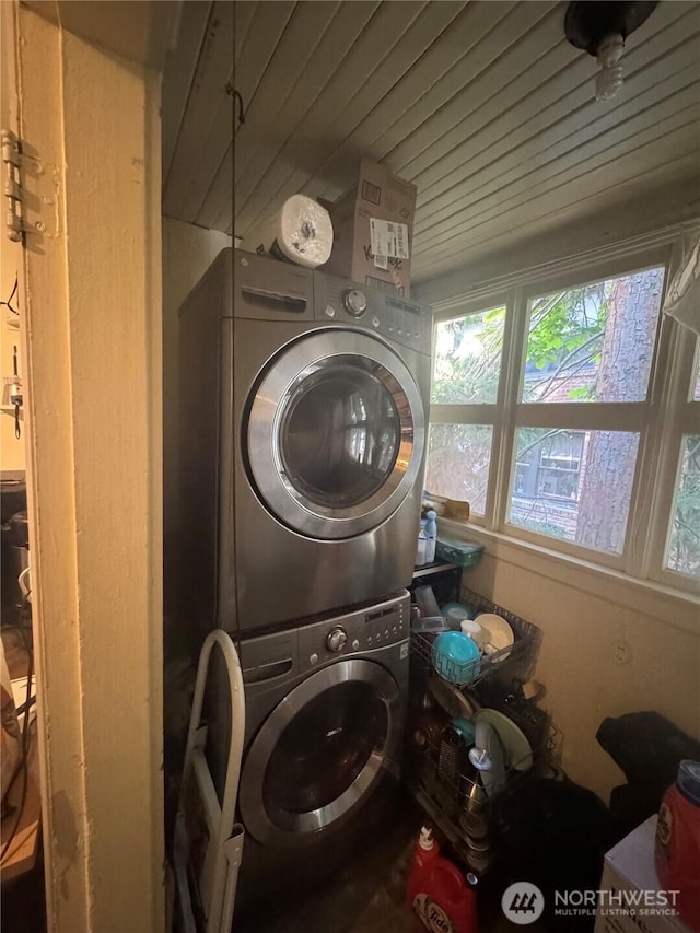 washroom featuring stacked washing maching and dryer, laundry area, and wooden ceiling