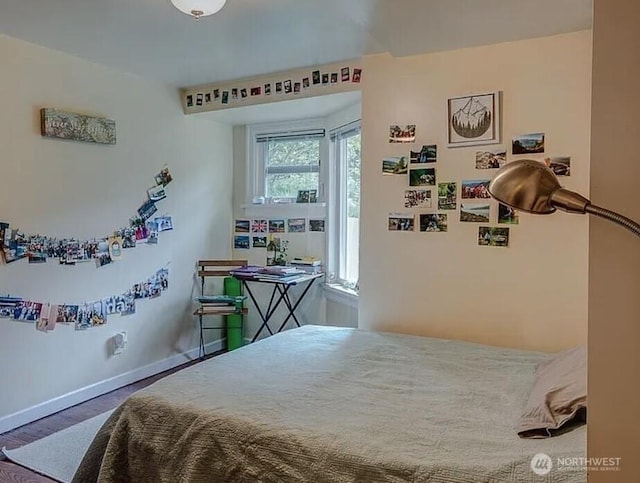 bedroom with baseboards and wood finished floors