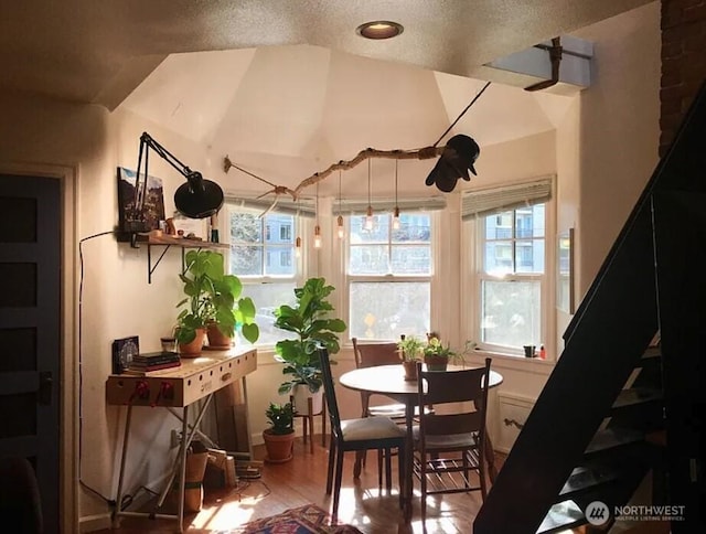 dining room with vaulted ceiling and wood finished floors