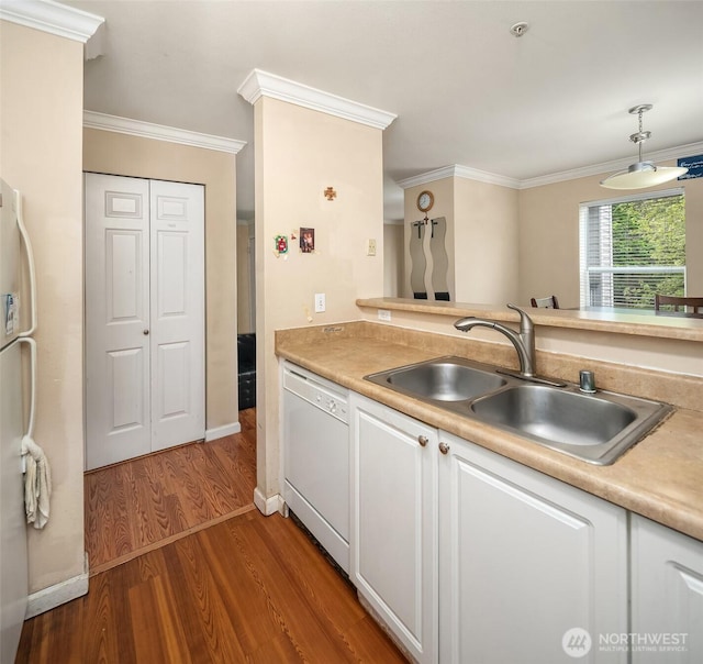 kitchen featuring white appliances, a sink, wood finished floors, white cabinets, and ornamental molding