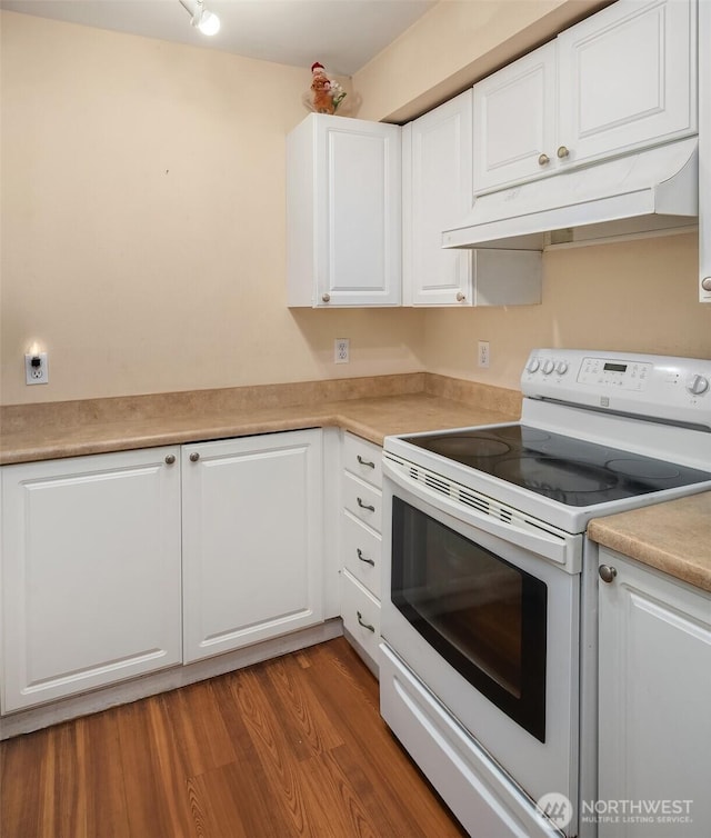 kitchen featuring white electric range, under cabinet range hood, white cabinetry, light countertops, and light wood-type flooring