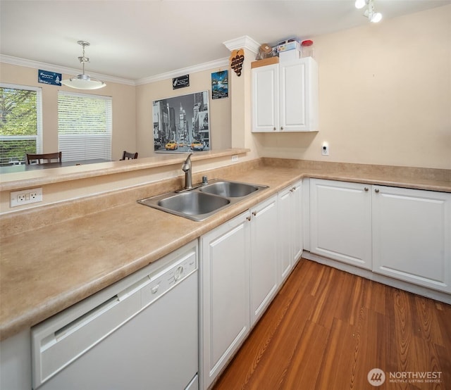 kitchen with dishwasher, a sink, white cabinets, light wood finished floors, and light countertops