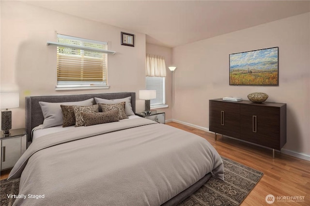 bedroom with wood finished floors and baseboards