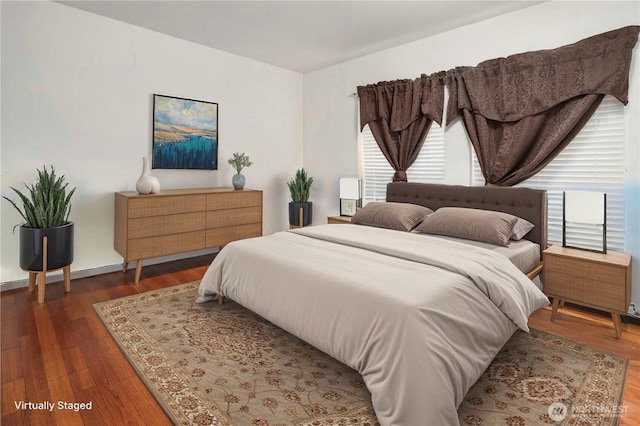bedroom with multiple windows and wood finished floors