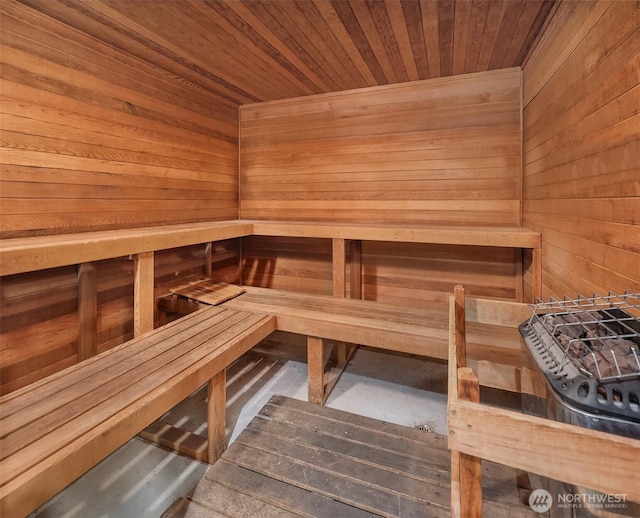 relaxing sauna featuring wood walls and wooden ceiling