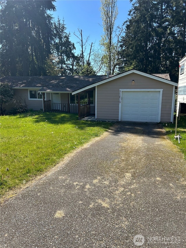 ranch-style house featuring a garage, a front lawn, and driveway