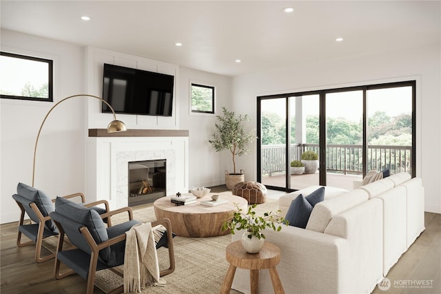 living room with a high end fireplace, recessed lighting, and wood finished floors