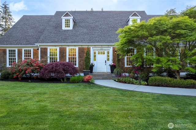 11281 Fieldstone Ln NE, Bainbridge Island, WA 98110 - cape cod house featuring a shingled roof and a front lawn