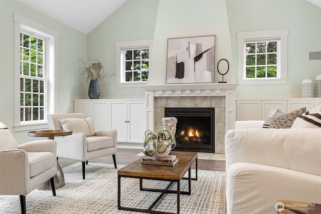 11281 Fieldstone Ln NE, Bainbridge Island, WA 98110 - living area featuring lofted ceiling, plenty of natural light, wood finished floors, and a tile fireplace