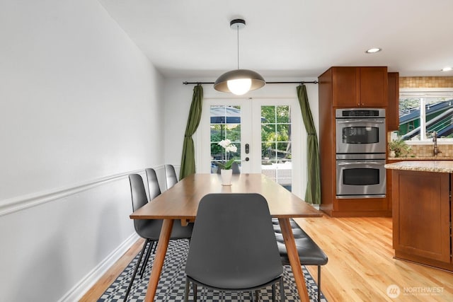 dining area with light wood-style flooring, french doors, and recessed lighting
