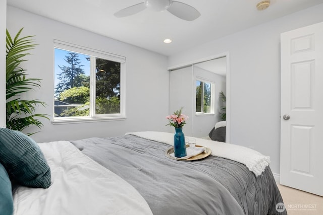 bedroom featuring a closet, ceiling fan, and light colored carpet