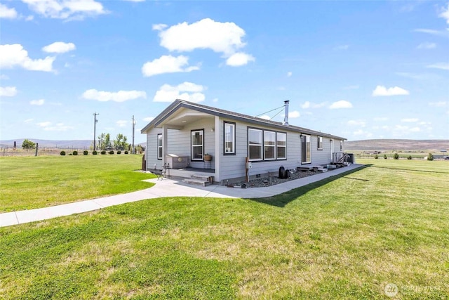 manufactured / mobile home with a rural view and a front lawn