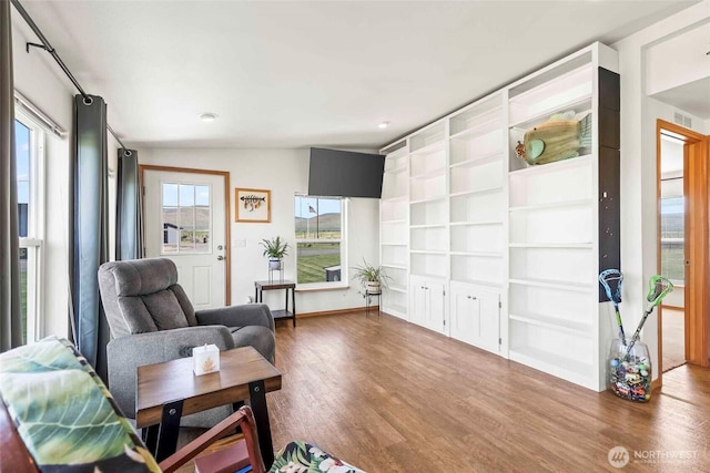 sitting room featuring built in features, recessed lighting, wood finished floors, and visible vents