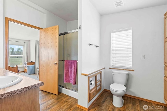 full bath featuring visible vents, wood finished floors, toilet, and a shower stall