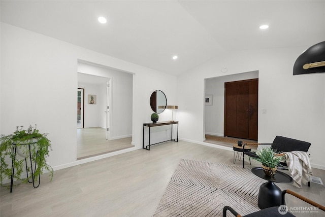 interior space with light wood-type flooring, recessed lighting, baseboards, and lofted ceiling