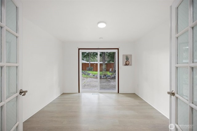 unfurnished room featuring french doors and wood finished floors