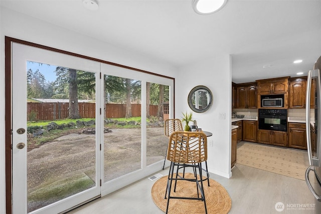 kitchen with visible vents, light wood-style floors, baseboards, light countertops, and stainless steel appliances