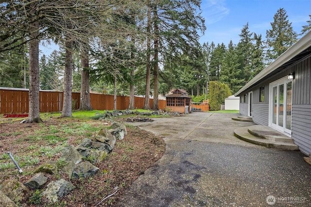 view of yard featuring entry steps, a gazebo, fence, and a patio area