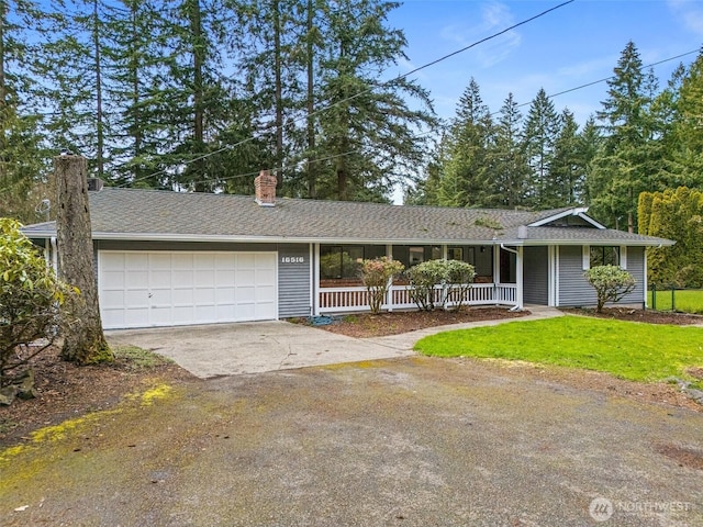 ranch-style house featuring a garage, a front yard, a chimney, concrete driveway, and a porch