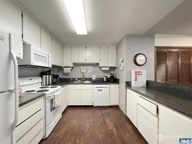 240 Parkwood Blvd, Sequim, WA 98382 - kitchen with white appliances, a sink, dark countertops, dark wood-type flooring, and white cabinetry