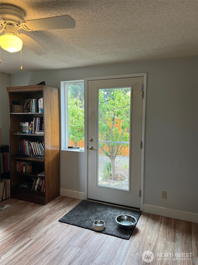 240 Parkwood Blvd, Sequim, WA 98382 - doorway with wood finished floors, baseboards, a textured ceiling, and ceiling fan