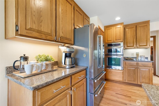 14320 2nd Ave NE, Marysville, WA 98271 - kitchen featuring light wood-style floors, appliances with stainless steel finishes, light stone counters, recessed lighting, and brown cabinets