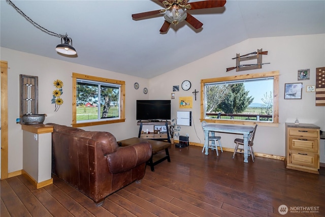 living area featuring baseboards, a ceiling fan, dark wood-style flooring, and vaulted ceiling