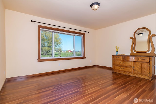 unfurnished bedroom with dark wood-type flooring and baseboards