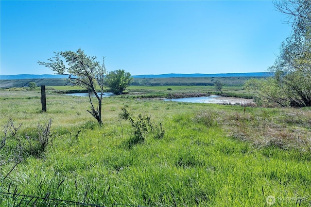 view of yard featuring a rural view and a water and mountain view