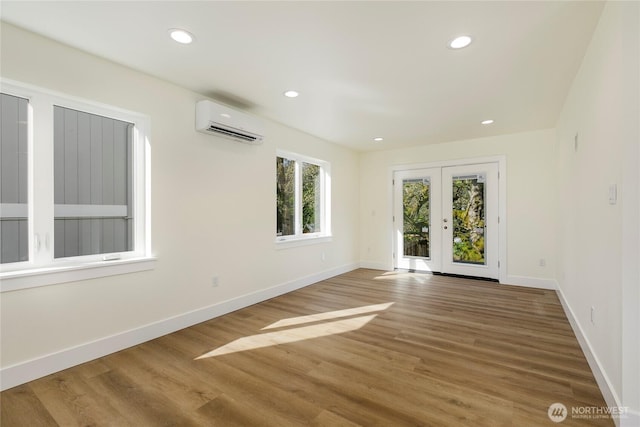 9253 6th Ave NW, Seattle, WA 98117 - unfurnished room with an AC wall unit, baseboards, and wood finished floors