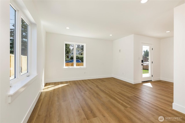 9253 6th Ave NW, Seattle, WA 98117 - empty room featuring baseboards, a healthy amount of sunlight, and wood finished floors