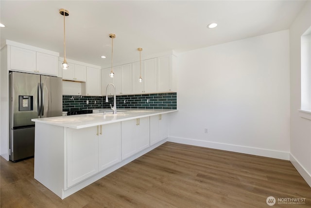9253 6th Ave NW, Seattle, WA 98117 - kitchen featuring tasteful backsplash, light countertops, white cabinets, a peninsula, and stainless steel fridge