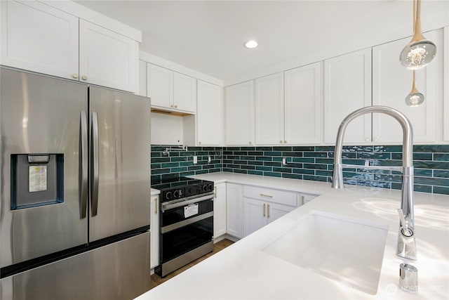 9253 6th Ave NW, Seattle, WA 98117 - kitchen featuring electric range oven, light countertops, a sink, stainless steel fridge, and white cabinetry