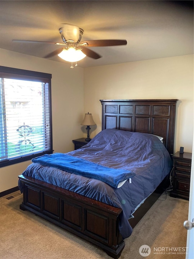 bedroom featuring a ceiling fan, baseboards, light colored carpet, and visible vents