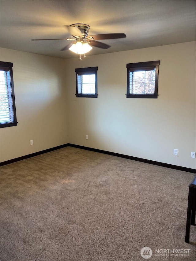 empty room featuring carpet floors, baseboards, and ceiling fan