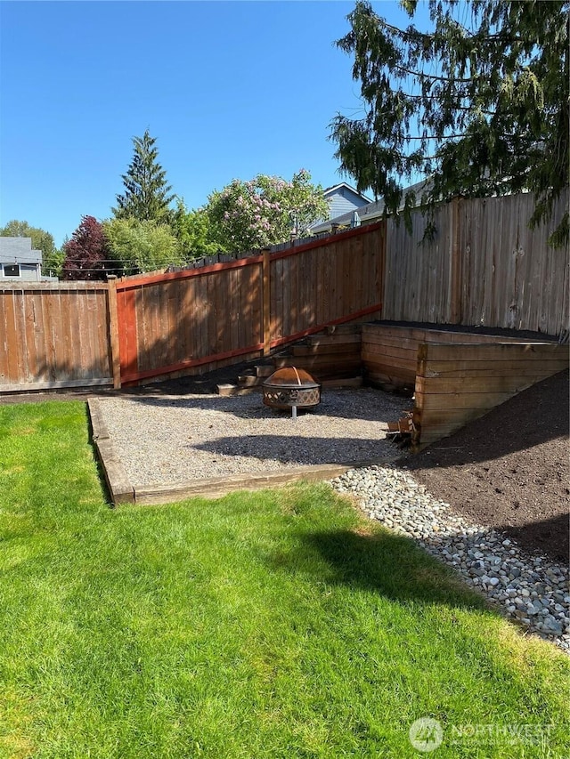 view of yard featuring a fenced backyard and an outdoor fire pit