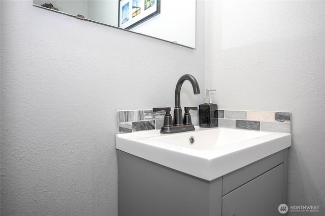 bathroom with vanity and a textured wall