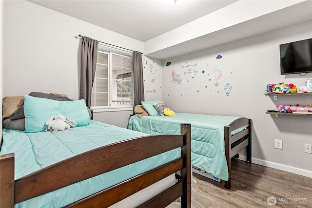 bedroom featuring baseboards and wood finished floors
