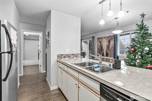 kitchen featuring a sink, light countertops, freestanding refrigerator, dark wood-style floors, and dishwashing machine
