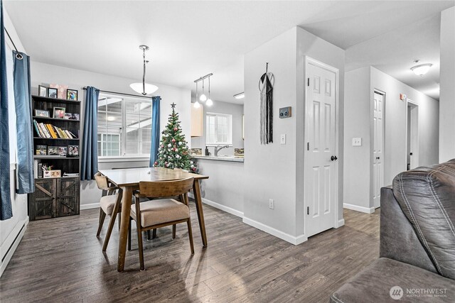 dining space featuring baseboards and dark wood finished floors