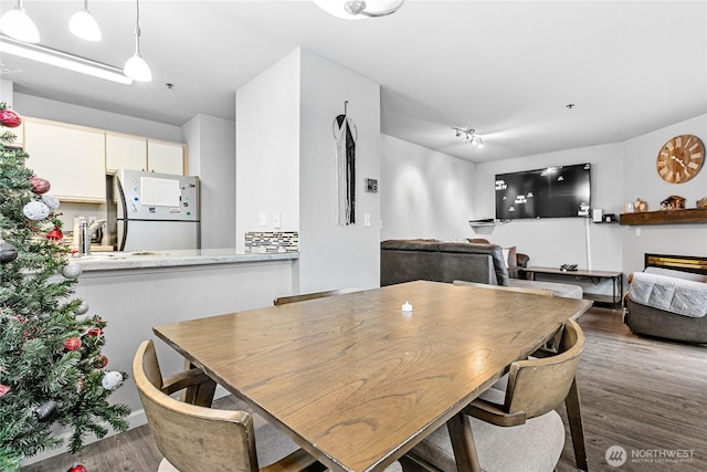 dining space with baseboards and wood finished floors