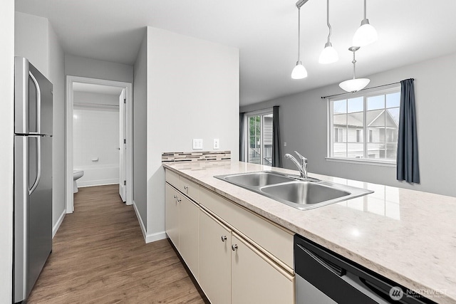 2709 Maplewood Ave Unit 304, Bellingham, WA 98225 - kitchen with dishwasher, a sink, freestanding refrigerator, light wood-style flooring, and hanging light fixtures