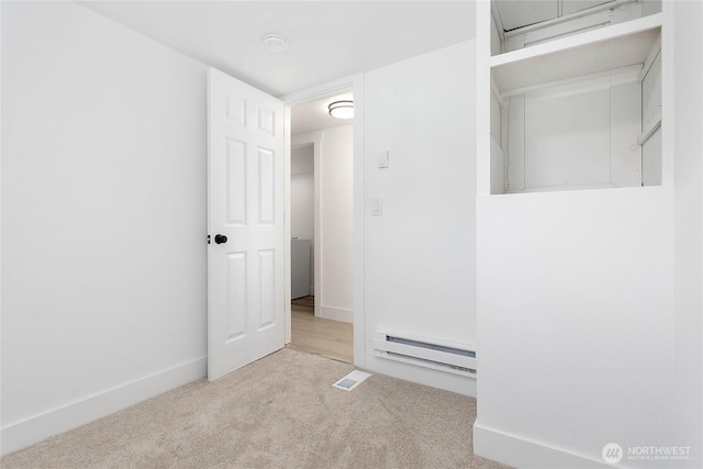 interior space with carpet floors, baseboards, and a baseboard heating unit