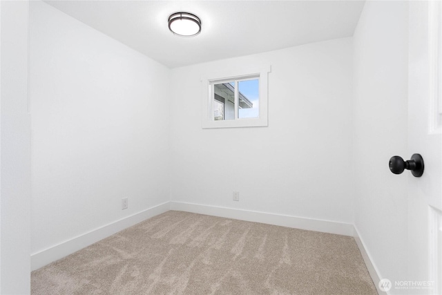 carpeted empty room featuring baseboards