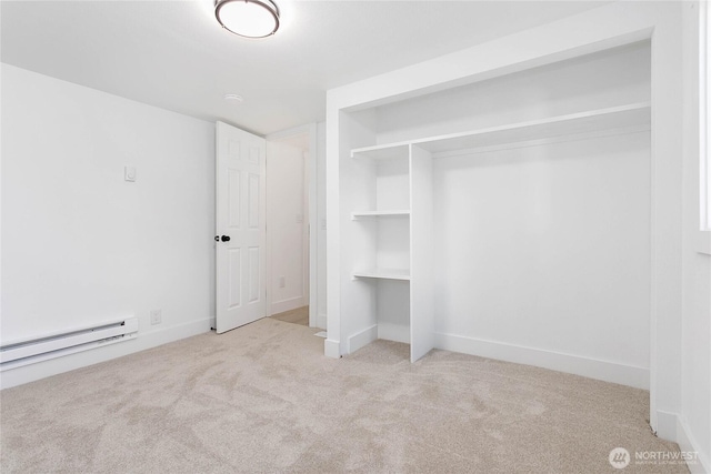 unfurnished bedroom with carpet flooring, baseboards, a baseboard heating unit, and a closet