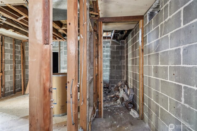 bathroom with gas water heater and concrete block wall