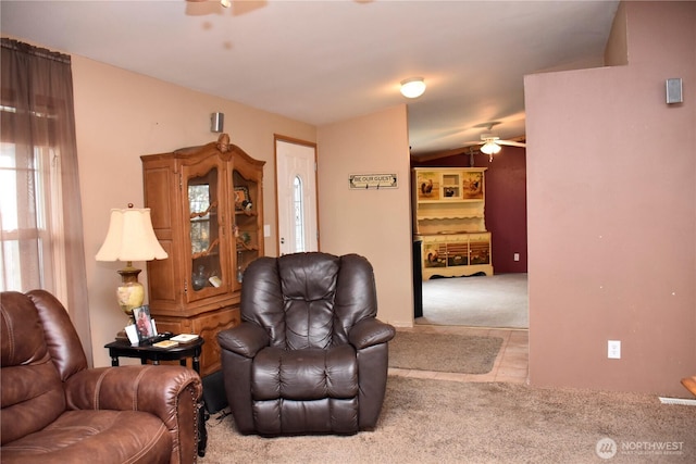 carpeted living room featuring ceiling fan and lofted ceiling