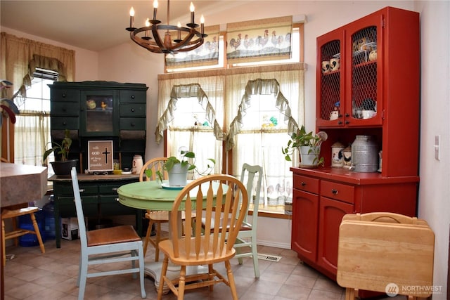 dining space featuring light tile patterned flooring and a chandelier