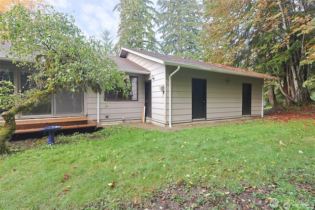 rear view of property featuring a lawn