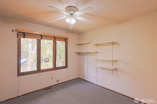 spare room with visible vents, baseboards, ceiling fan, a textured ceiling, and carpet flooring